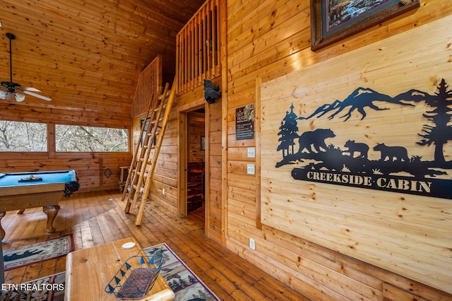 exterior space with wood walls, billiards, ceiling fan, and wood-type flooring