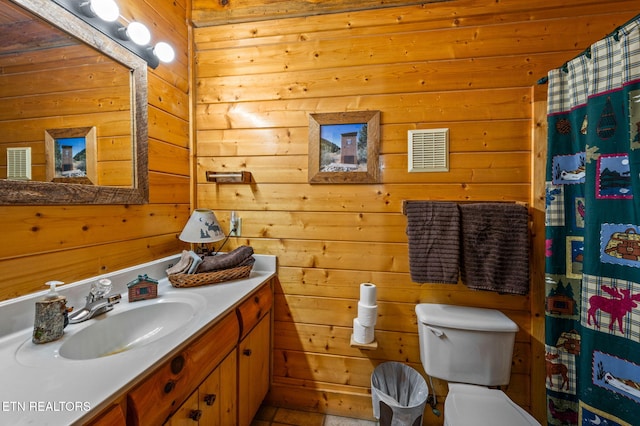 bathroom featuring visible vents, curtained shower, wood walls, toilet, and vanity