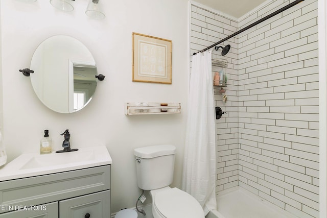 full bathroom featuring vanity, a shower stall, and toilet