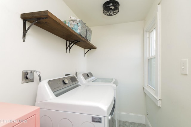 clothes washing area featuring baseboards, laundry area, and washer and clothes dryer