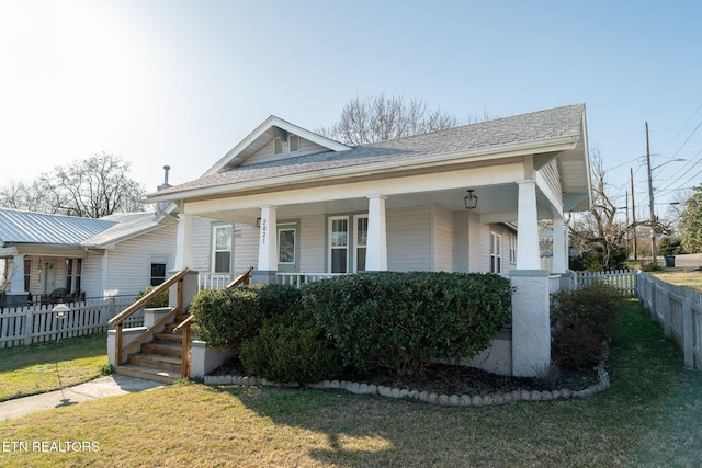 bungalow with covered porch, a front yard, and fence