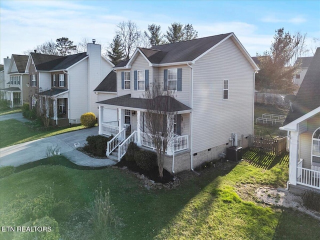 traditional-style home featuring a front yard, central AC unit, a porch, concrete driveway, and crawl space