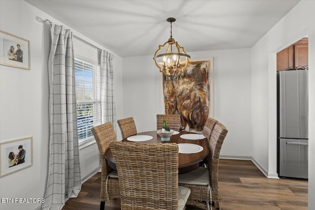 dining area featuring a notable chandelier, wood finished floors, and baseboards