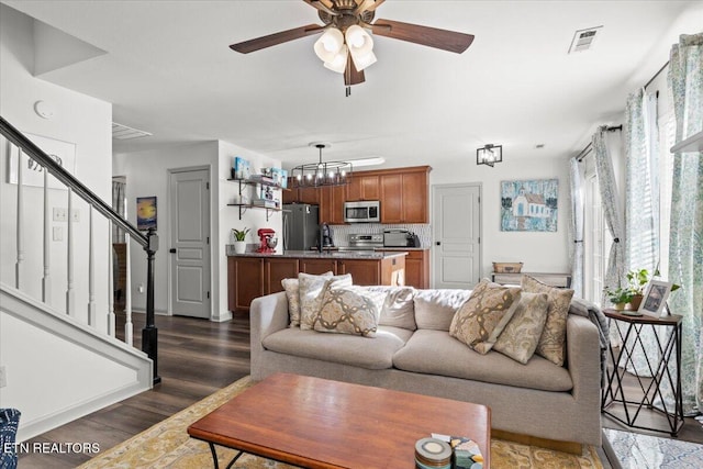 living area with a wealth of natural light, visible vents, stairway, and dark wood-style flooring