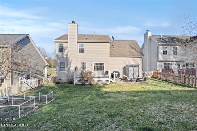 rear view of property featuring a deck, a yard, a fenced backyard, and a chimney