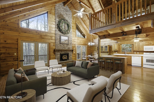 living room featuring a stone fireplace, wooden ceiling, a ceiling fan, and light wood-type flooring