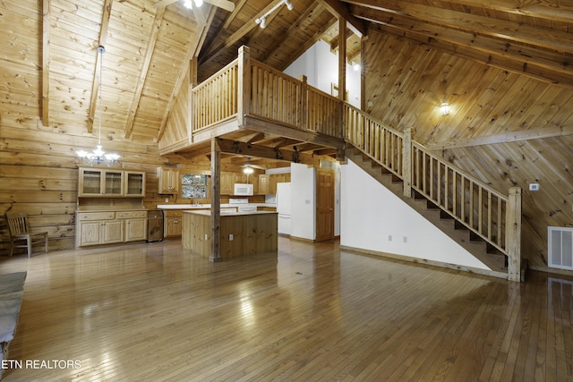 unfurnished living room with beam ceiling, wooden walls, wood ceiling, and hardwood / wood-style floors