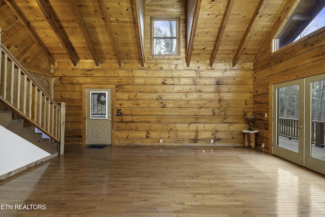 empty room with wooden ceiling, stairway, vaulted ceiling with beams, and wood finished floors