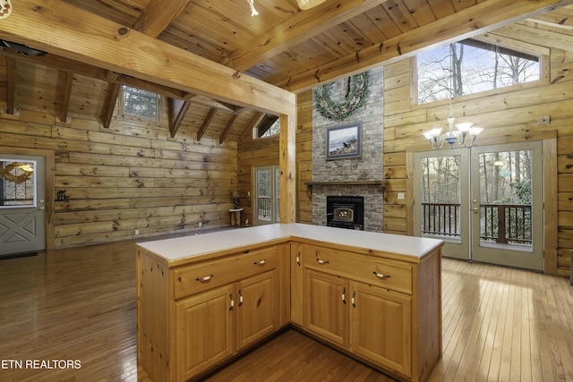 kitchen featuring light wood-style floors, wood ceiling, a fireplace, and vaulted ceiling with beams