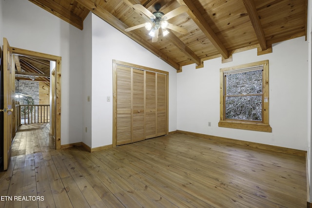 unfurnished bedroom with a closet, beam ceiling, wooden ceiling, and hardwood / wood-style flooring