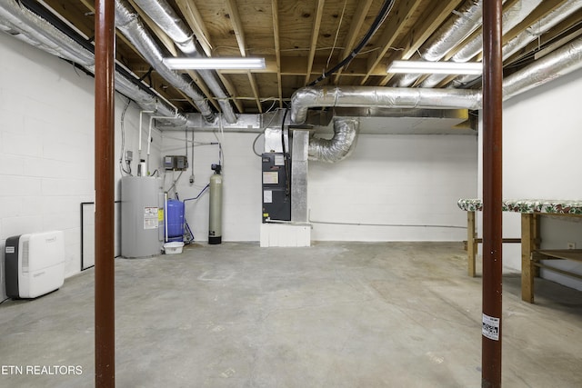 unfinished basement with water heater, heating unit, and concrete block wall