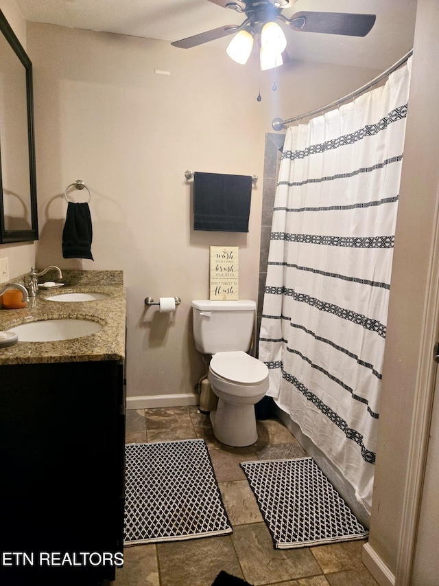 bathroom with vanity, toilet, a shower with curtain, and baseboards