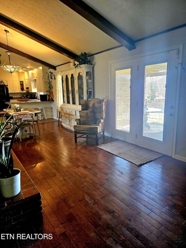 living room featuring beam ceiling and hardwood / wood-style floors