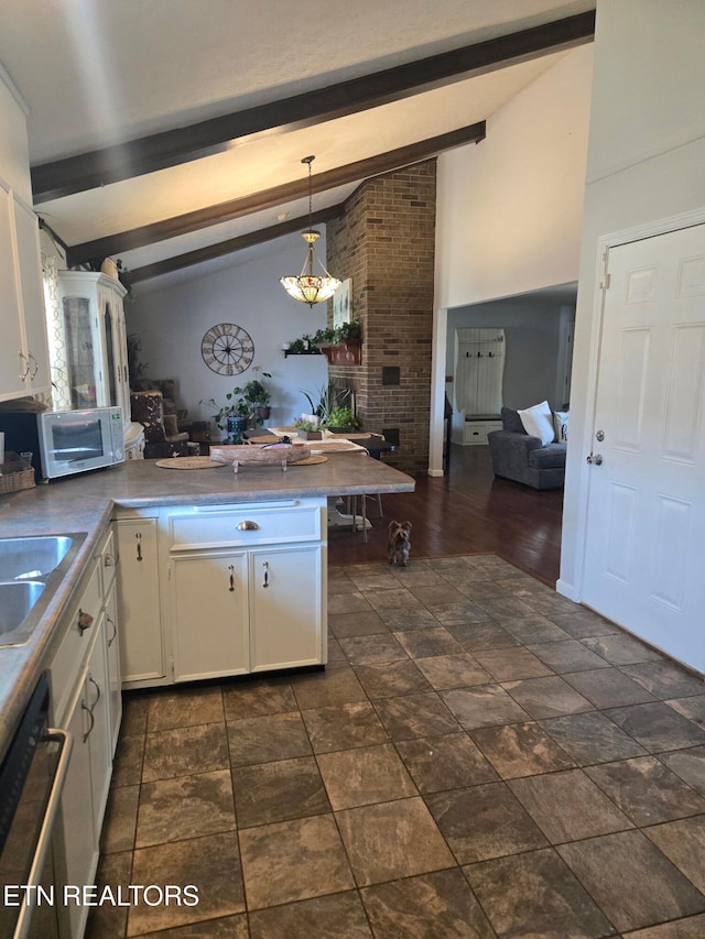 kitchen with vaulted ceiling with beams, pendant lighting, dishwashing machine, a peninsula, and white cabinets