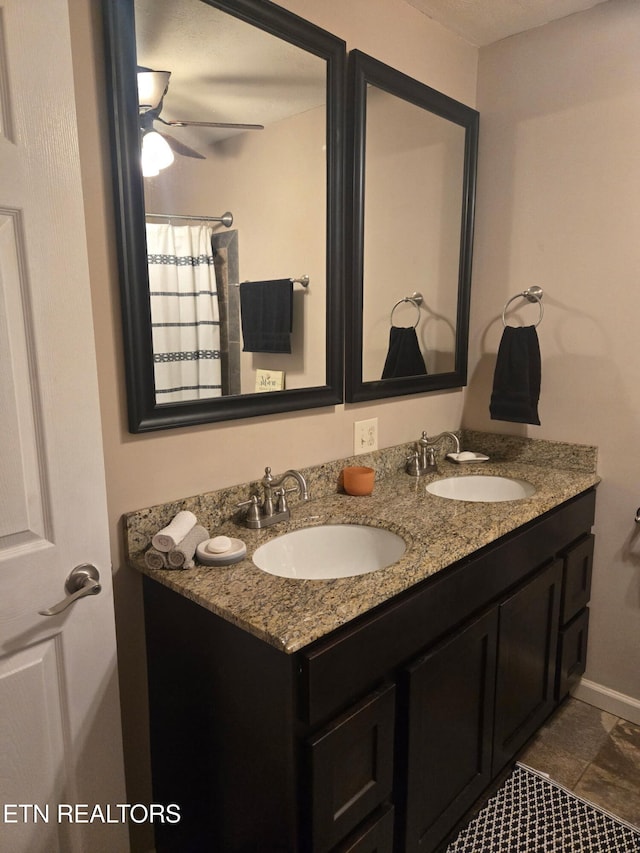 full bathroom with a sink, ceiling fan, and double vanity