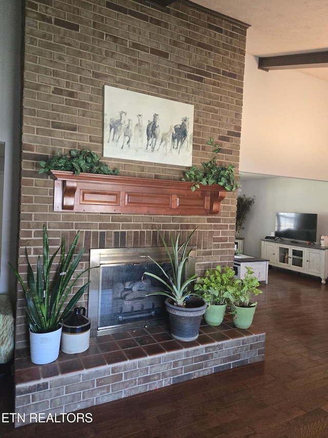 interior details featuring beamed ceiling, wood finished floors, and a fireplace