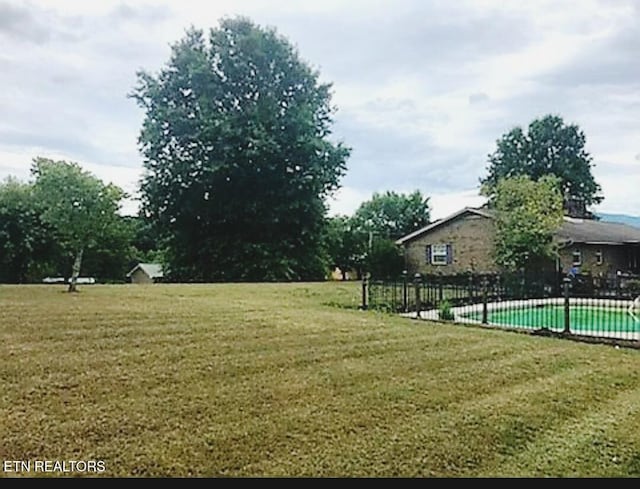 view of yard with a fenced in pool and fence