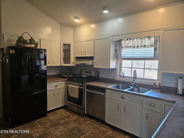 kitchen with a sink, under cabinet range hood, appliances with stainless steel finishes, white cabinetry, and tasteful backsplash