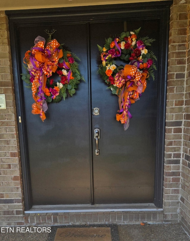 doorway to property with brick siding