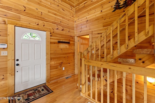 foyer with a sauna, wooden walls, and light wood finished floors