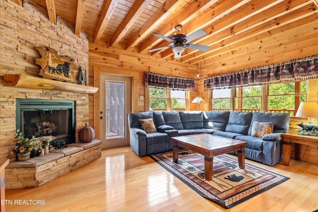 living area with wooden walls, wood ceiling, beam ceiling, a ceiling fan, and wood-type flooring