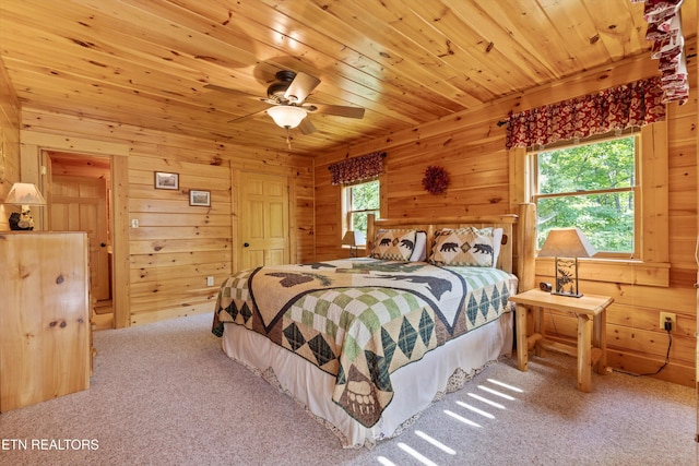 bedroom with carpet floors, wooden walls, wood ceiling, and ceiling fan