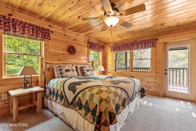 bedroom with wooden walls, wood ceiling, carpet, and access to outside