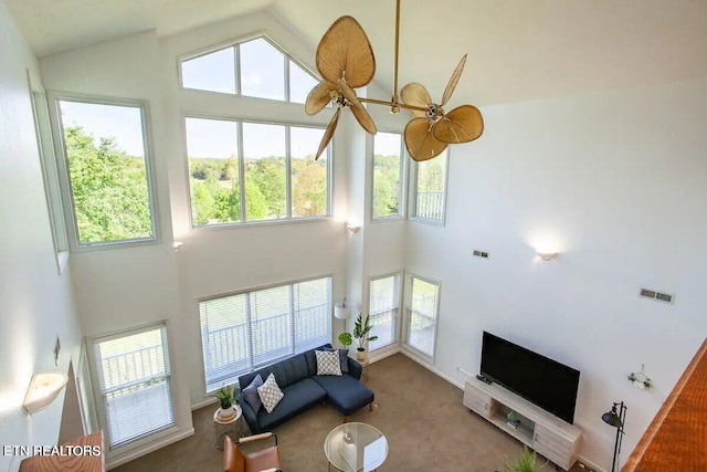 carpeted living area featuring visible vents, high vaulted ceiling, and ceiling fan