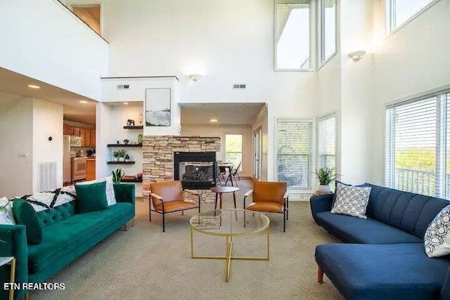 living room featuring visible vents and a stone fireplace