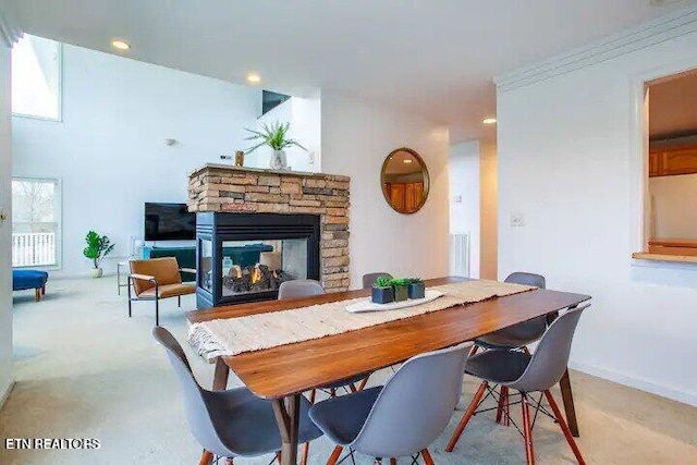 dining space featuring light colored carpet, recessed lighting, a fireplace, and baseboards