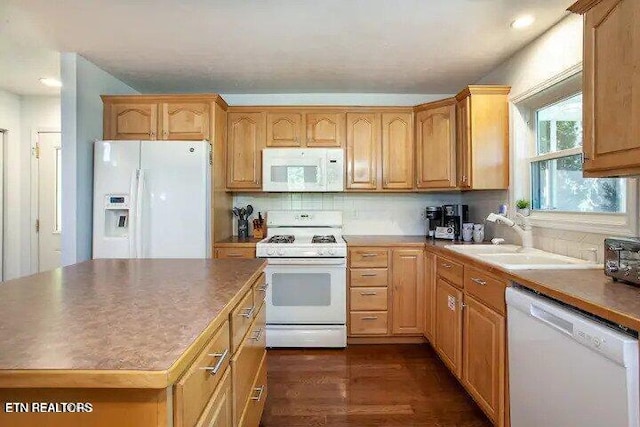 kitchen with white appliances, dark wood-style floors, a sink, tasteful backsplash, and a center island