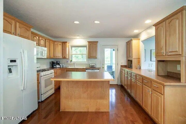 kitchen with white appliances, dark wood-style floors, a kitchen island, recessed lighting, and light countertops