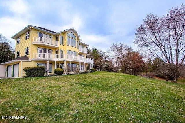 back of property featuring a yard and a balcony
