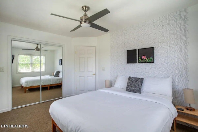 carpeted bedroom with a closet, a ceiling fan, and an accent wall
