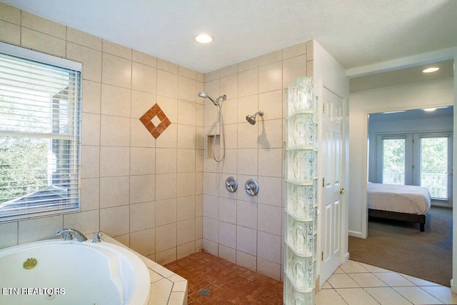 ensuite bathroom with tile walls, a tile shower, a bath, tile patterned floors, and ensuite bath
