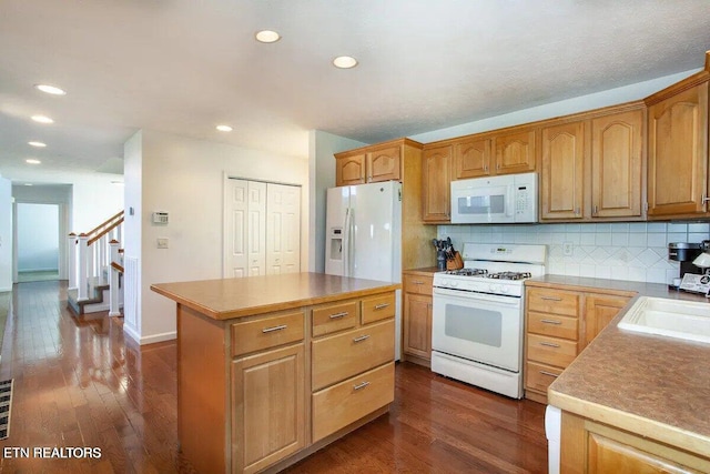 kitchen featuring backsplash, white appliances, a kitchen island, and dark wood-type flooring