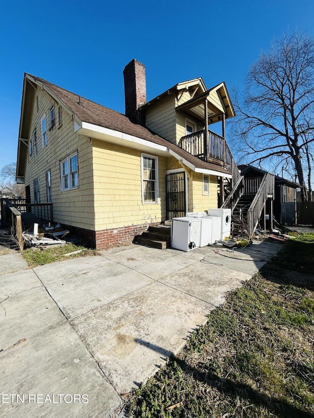 rear view of property featuring a balcony, a chimney, and a patio area