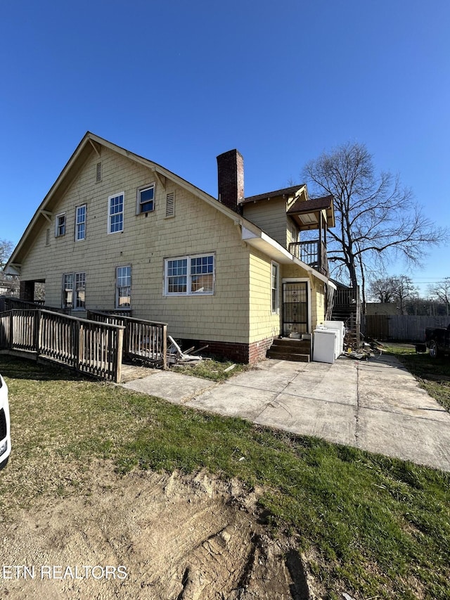 rear view of property featuring a patio area, a chimney, and fence