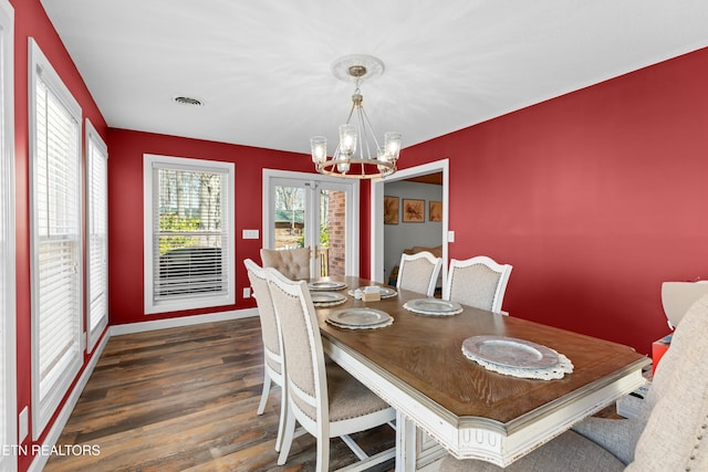 dining space with an inviting chandelier, dark wood-style floors, visible vents, and baseboards