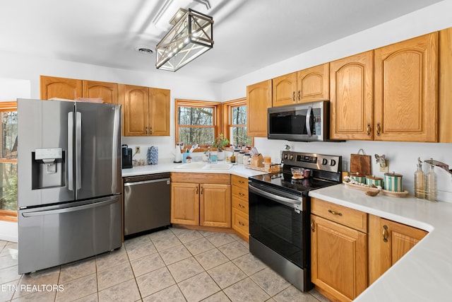 kitchen featuring visible vents, light countertops, appliances with stainless steel finishes, light tile patterned flooring, and a sink