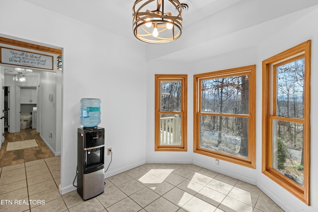 dining space featuring light tile patterned floors, an inviting chandelier, and baseboards