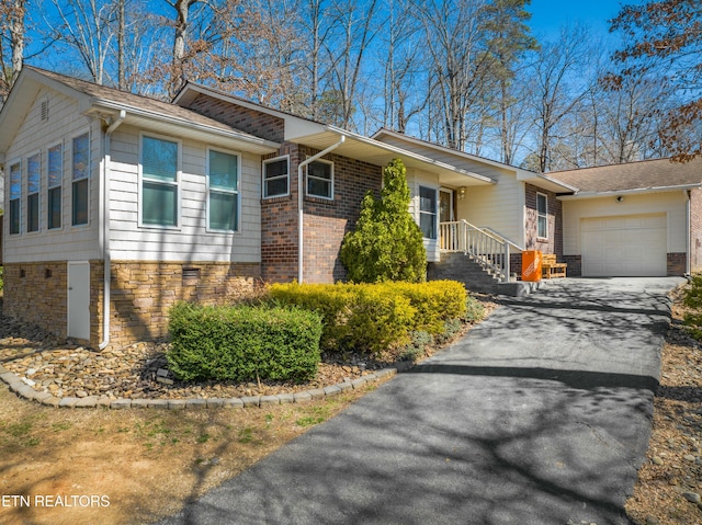 view of front of home featuring brick siding, driveway, and a garage