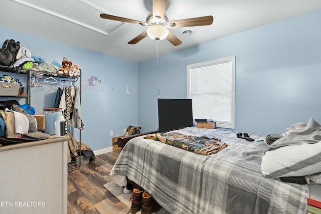 bedroom with visible vents, ceiling fan, baseboards, and wood finished floors