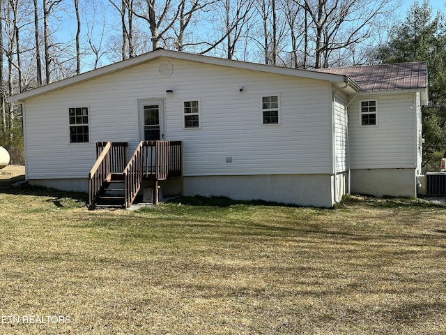 back of house with cooling unit, a lawn, and metal roof