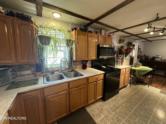 kitchen featuring stainless steel microwave, black range with electric cooktop, light countertops, brown cabinetry, and a sink