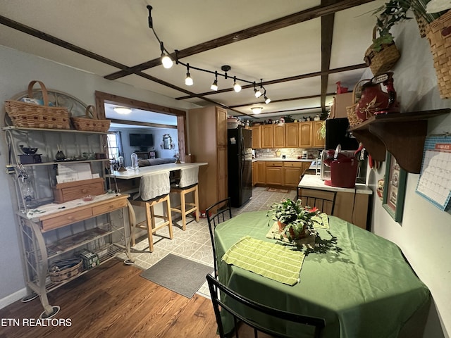 dining space featuring baseboards and light wood finished floors