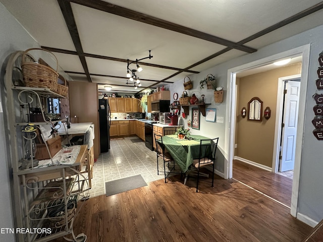 dining space featuring beamed ceiling, light wood-style floors, and baseboards