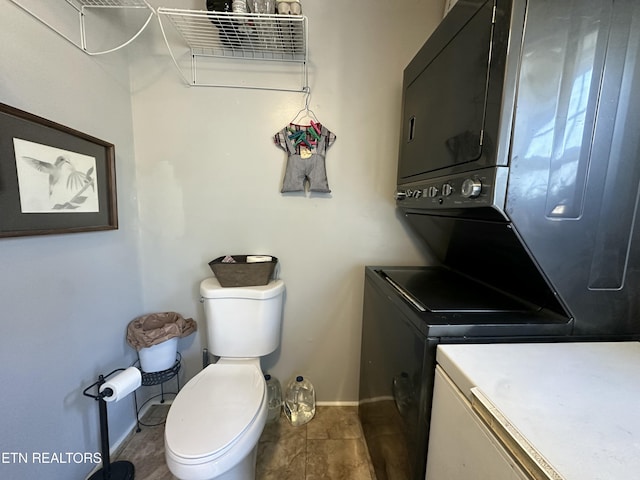 laundry room with laundry area, baseboards, and stacked washer and clothes dryer