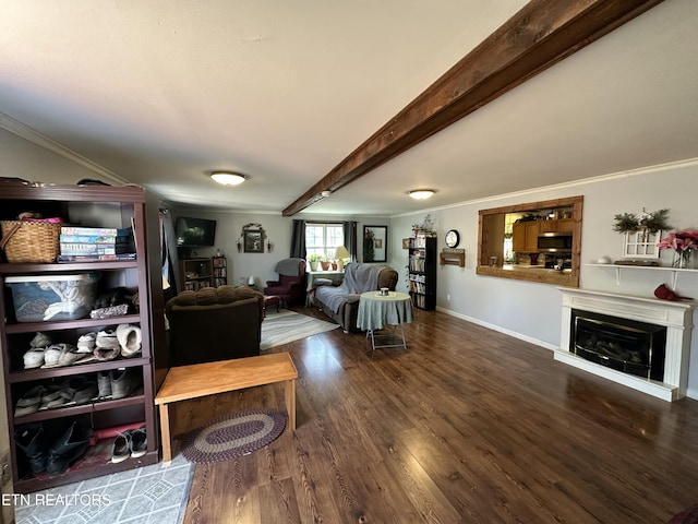 living area with beam ceiling, wood finished floors, a fireplace, and ornamental molding