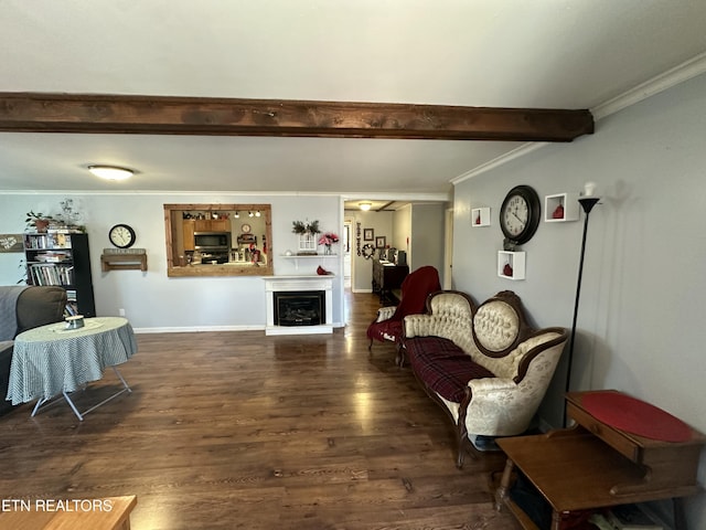 living area featuring baseboards, ornamental molding, beam ceiling, a fireplace, and wood finished floors